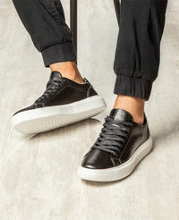 Tênis casual preto RS6 no pé em look masculino